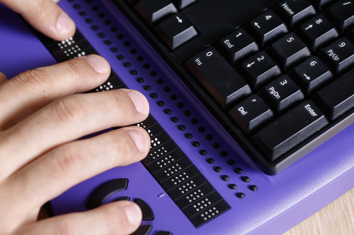 Hands typing on a Braille keyboard