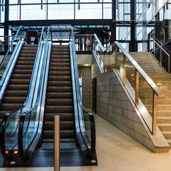 An escalator and a staircase in a mall.