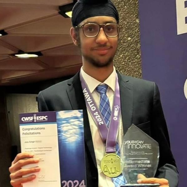 Jora Singh holding a certificate and an award at a science fair.