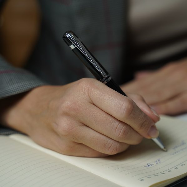 A hand writing in a notebook.