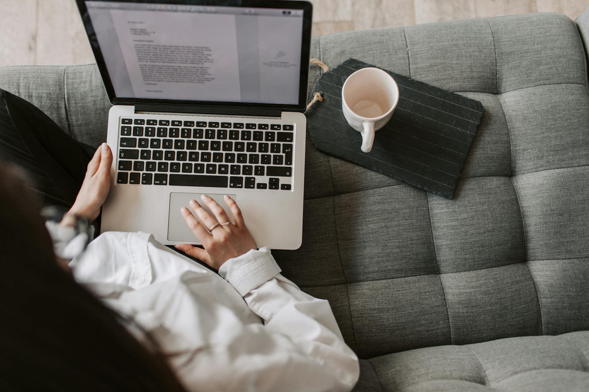 A woman looks at a word doc on her laptop.