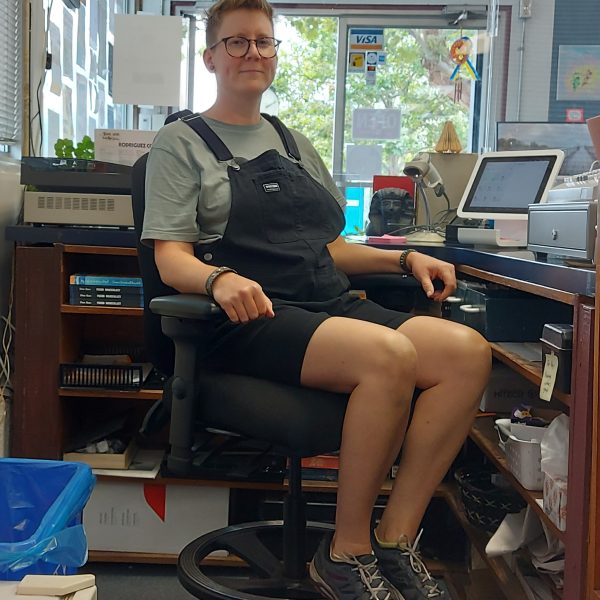 Leanne sitting at her desk in her ergonomic chair at work.