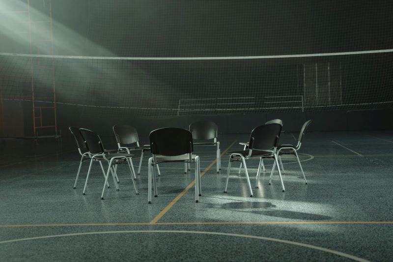 A circle of chairs in a gymnasium.