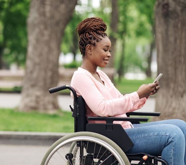 A woman in a wheelchair uses her phone