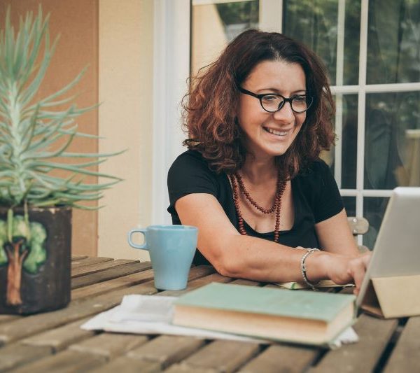 A person smiles using a tablet.