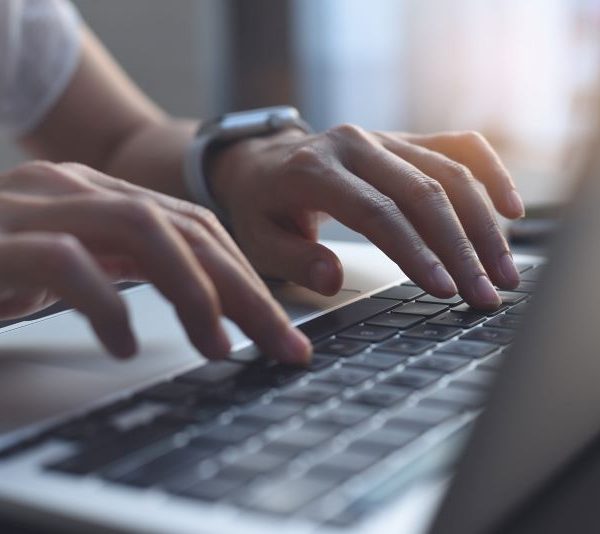 A person types on a laptop.